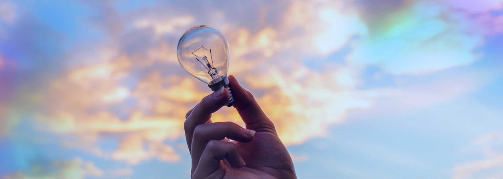 Mano sosteniendo un foco hacia el cielo innovación empresarial